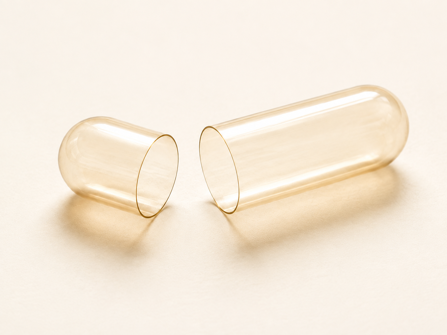 Illustrative pale amber empty capsule shell with its cap and body separated
